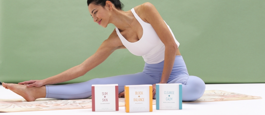 Image of a woman doing yoga in workout gear with the NeoraFit product packages in the foreground.